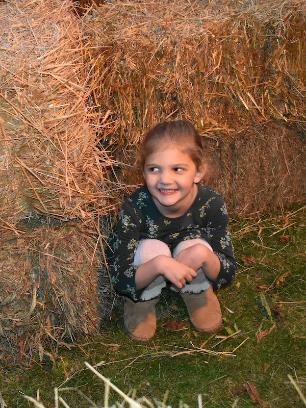 A young girl huddles inside a hay maze at Halloween Legends & Lore at Old World Wisconsin